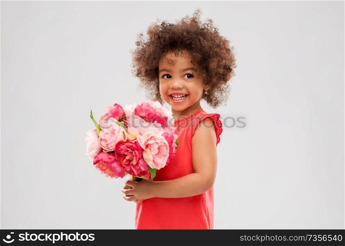 childhood and people concept - happy little african american girl with flowers over grey background. happy little african american girl with flowers