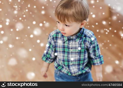 childhood and people concept - happy little baby boy at home over snow. happy little baby boy at home