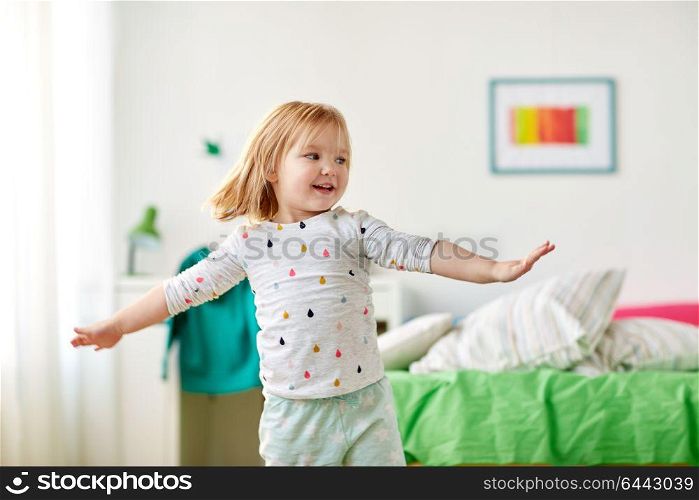 childhood and people concept - happy little girl having fun at home. happy little girl having fun at home