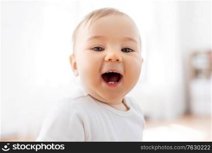 childhood and people concept - portrait of happy laughing little baby at home. portrait of happy laughing little baby at home
