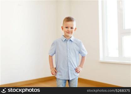 childhood and people concept - smiling little boy at empty room of new home. smiling little boy at empty room of new home