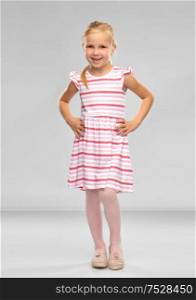 childhood and people concept - smiling little girl in striped dress over grey background. smiling little girl in striped dress