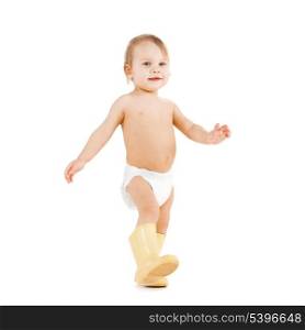 childhood and toys concept - cute little boy walking in big rubber boots
