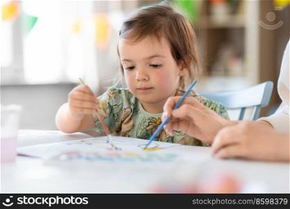 childhood, art and leisure concept - little baby girl drawing at home or kindergarten. little baby girl drawing at home or kindergarten