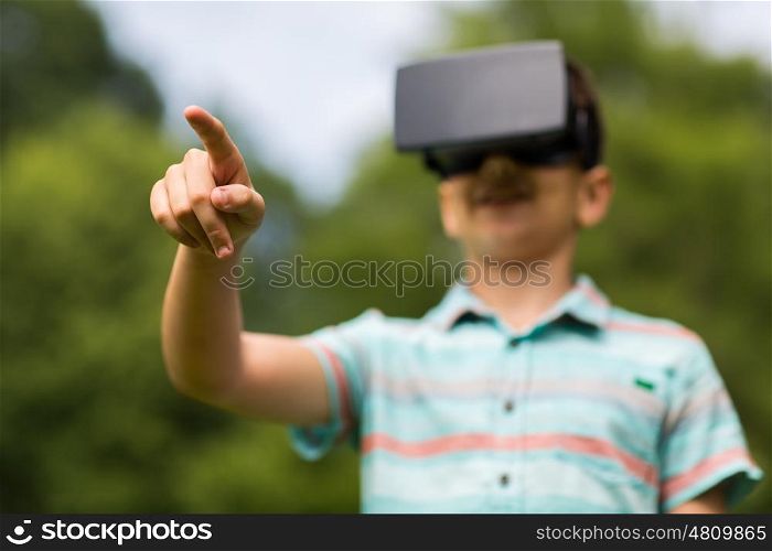 childhood, augmented reality, technology and people concept - boy with virtual headset or 3d glasses playing game outdoors at summer