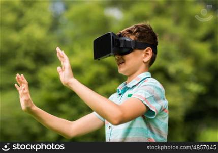 childhood, augmented reality, technology and people concept - boy with virtual headset or 3d glasses playing game outdoors at summer