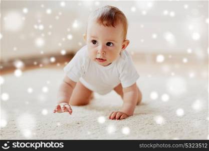childhood, babyhood and people concept - happy little baby boy or girl crawling on floor at home over snow. little baby in diaper crawling on floor at home