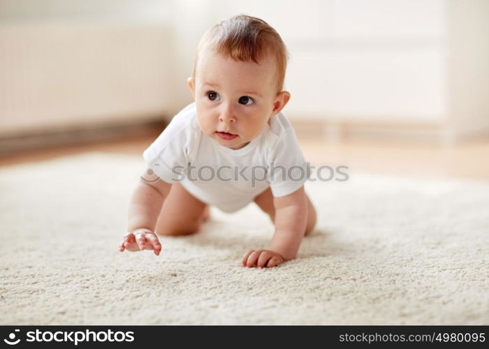 childhood, babyhood and people concept - little baby boy or girl crawling on floor at home. little baby in diaper crawling on floor at home