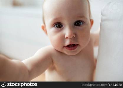 childhood, babyhood, emotions and people concept - close up of happy little baby boy or girl at home