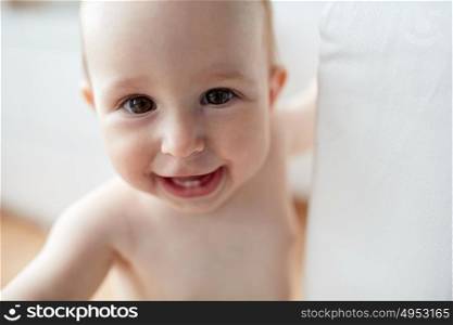 childhood, babyhood, emotions and people concept - close up of happy little baby boy or girl at home. close up of happy little baby boy or girl at home