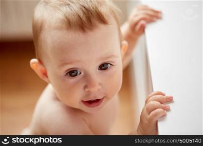childhood, babyhood, emotions and people concept - close up of happy little baby boy or girl at home. happy little baby boy or girl at home
