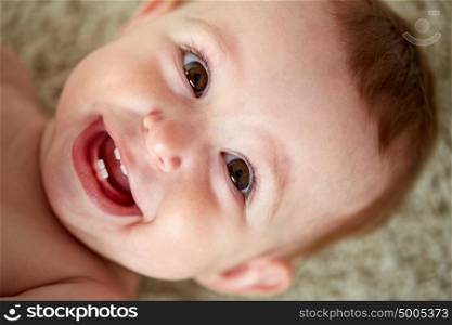childhood, babyhood, emotions and people concept - close up of happy little baby boy or girl face. close up of happy little baby boy or girl face