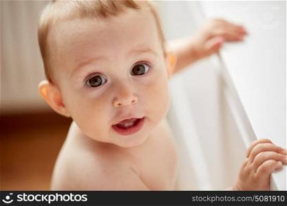 childhood, babyhood, emotions and people concept - close up of happy little baby boy or girl at home. happy little baby boy or girl at home