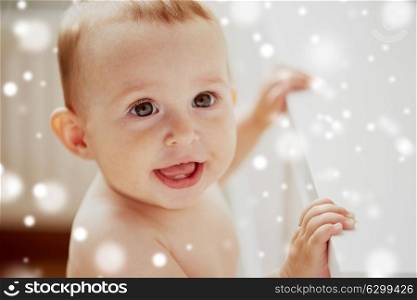 childhood, babyhood, emotions and people concept - face of happy little baby boy or girl holding to table over snow. face of happy little baby boy or girl