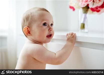 childhood, babyhood, emotions and people concept - happy little baby boy or girl at home