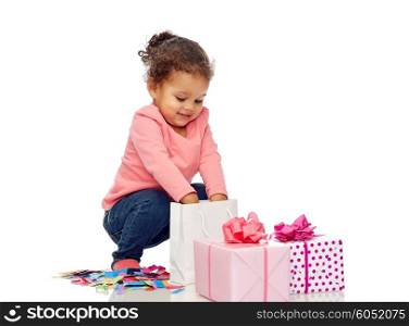 childhood, birthday, party, holidays and people concept - happy smiling little african american baby girl with gift boxes playing with confetti and shopping bag