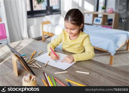 childhood, creativity and art concept - close up of little girl with coloring pencils drawing witch on paper at home. little girl drawing with coloring pencils at home