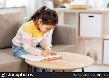 childhood, creativity and art concept - little girl drawing with coloring pencils at home. little girl drawing with coloring pencils at home