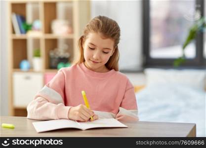 childhood, creativity and hobby concept - creative little girl with notebook and marker drawing at home. girl with notebook and marker drawing at home