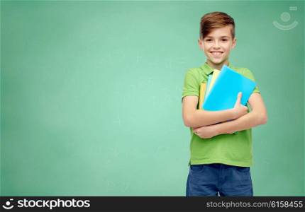 childhood, education and people concept - happy smiling student boy with folders and notebooks over green school chalk board background