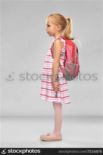 childhood, education and people concept - happy student girl with school bag over grey background. happy student girl with school bag