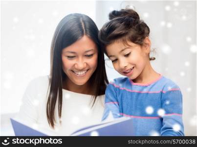 childhood, education, family and people concept - smiling little girl and mother or teacher with book indoors