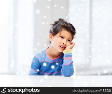 childhood, emotions and people concept - sad or tired little girl indoors