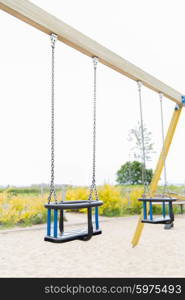 childhood, equipment and object concept - baby swing on playground outdoors