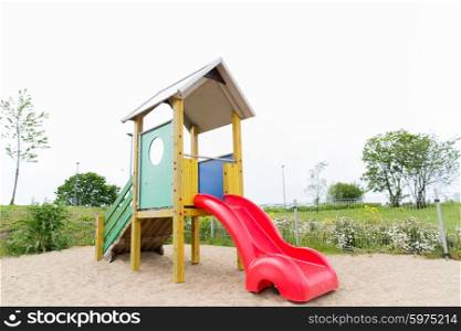 childhood, equipment and object concept - slide on playground outdoors