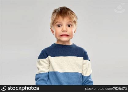 childhood, expressions and people concept - shocked little boy in striped pullover over grey background. shocked little boy in striped pullover