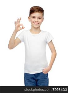 childhood, fashion, advertisement and people concept - happy boy in white t-shirt and jeans showing ok hand sign