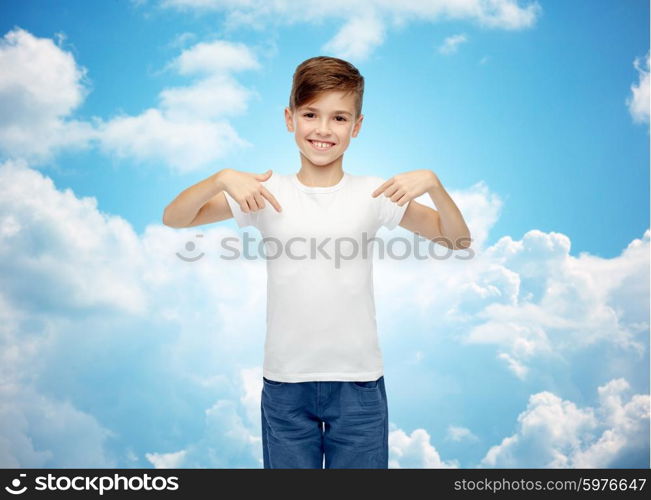 childhood, fashion, advertisement and people concept - happy boy in white t-shirt and jeans pointing finger to himself over blue sky and clouds background