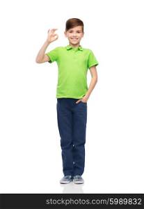 childhood, fashion, advertisement and people concept - happy boy in white t-shirt and jeans showing ok hand sign