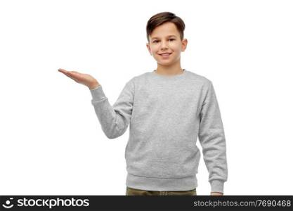 childhood, fashion and people concept - happy smiling boy holding something imaginary on his hand over white background. happy boy holding something imaginary on hand