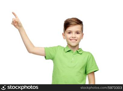 childhood, fashion and people concept - happy smiling boy in green polo t-shirt pointing finger up