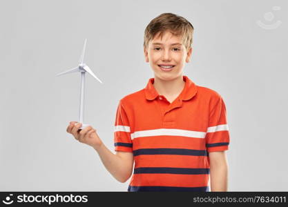 childhood, fashion and people concept - portrait of happy smiling boy in red polo t-shirt with toy wind turbine over grey background. happy smiling boy holding toy wind turbine