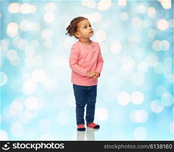 childhood, fashion, clothing and people concept - beautiful african american little baby girl portrait over blue holidays lights background