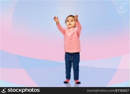childhood, fashion, clothing and people concept - beautiful little african american baby girl playing with soap bubble over pink violet background