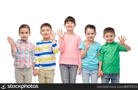 childhood, fashion, friendship and people concept - group of happy smiling little children holding hands