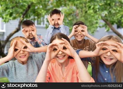 childhood, fashion, friendship and people concept - happy children making faces and having fun over private house backyard background