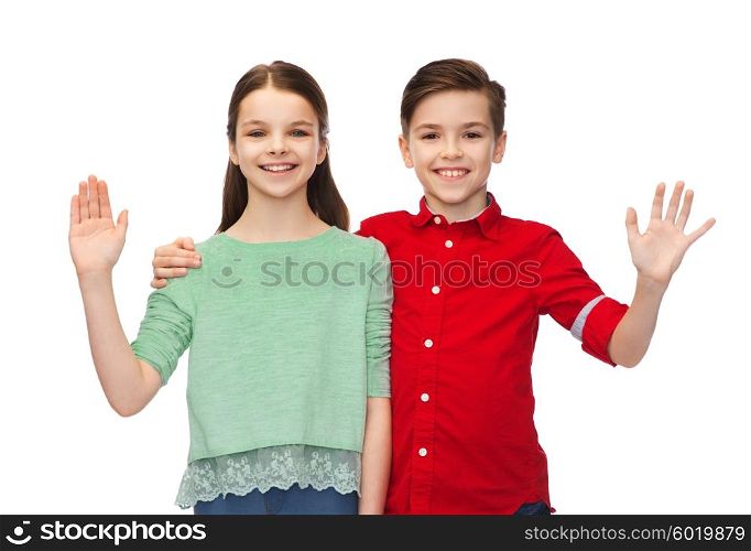 childhood, fashion, gesture and people concept - happy smiling boy and girl hugging and waving hand