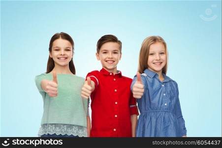 childhood, fashion, gesture and people concept - happy smiling boy and girls showing thumbs up over blue background