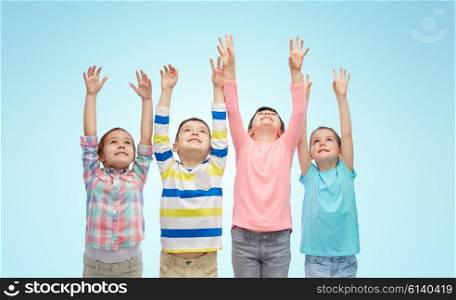 childhood, fashion, gesture and people concept - happy smiling children raising fists and celebrating victory over blue background