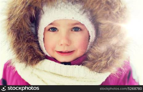 childhood, fashion, season and people concept - face of happy little kid or girl in winter clothes. face of happy little kid or girl in winter clothes