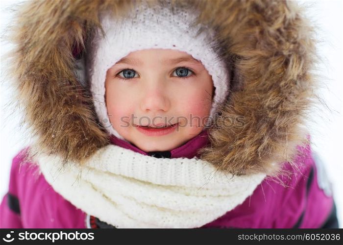 childhood, fashion, season and people concept - face of happy little kid or girl in winter clothes