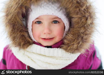 childhood, fashion, season and people concept - face of happy little kid or girl in winter clothes