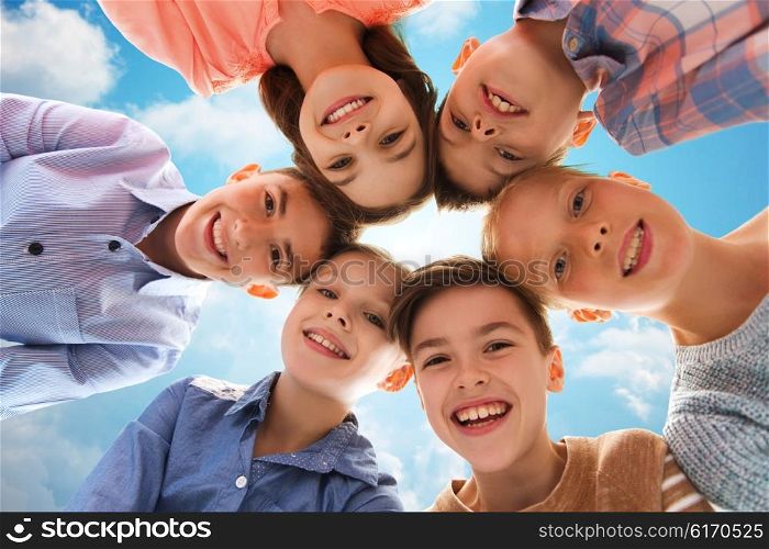 childhood, fashion, summer, friendship and people concept - happy smiling children faces over blue sky and clouds background