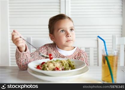 childhood, food and people concept - little girl eating pasta for dinner at restaurant or cafe