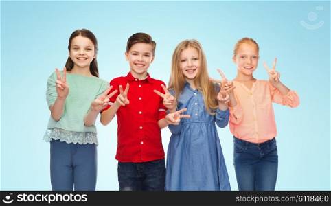 childhood, friendship and people concept - happy smiling boy and girls showing peace hand sign over blue background
