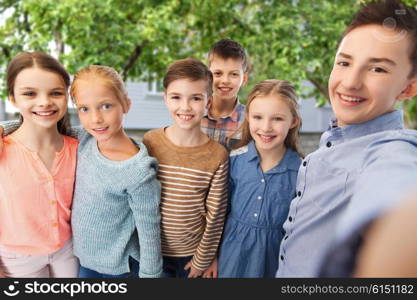 childhood, friendship, technology and people concept - happy children talking selfie over private house backyard background